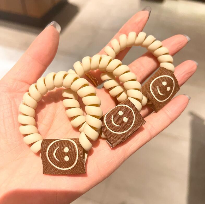 Achieve a cute look with our Milk Tea Frosted Hair Circle, featuring a smiley face rope for girls' hair. - Bloomjay