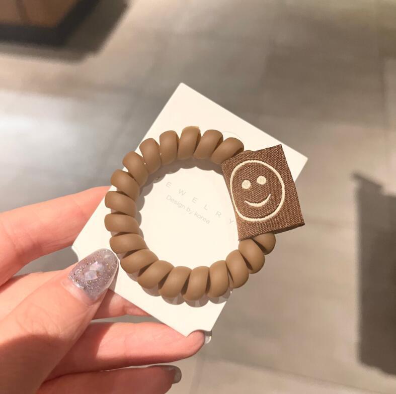 Achieve a cute look with our Milk Tea Frosted Hair Circle, featuring a smiley face rope for girls' hair. - Bloomjay