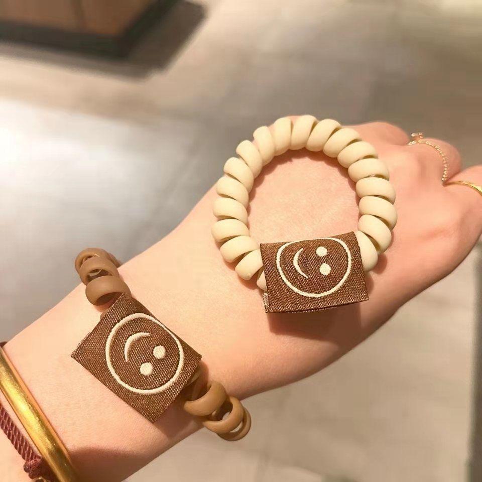 Achieve a cute look with our Milk Tea Frosted Hair Circle, featuring a smiley face rope for girls' hair. - Bloomjay