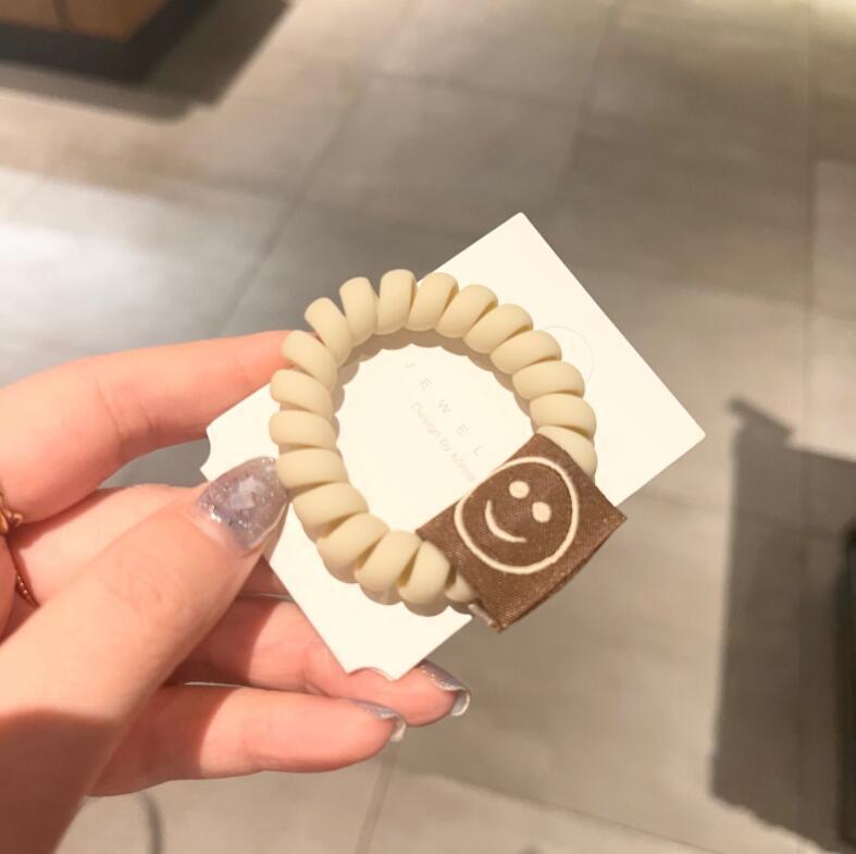 Achieve a cute look with our Milk Tea Frosted Hair Circle, featuring a smiley face rope for girls' hair.