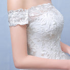 In the summer, envision a bride adorned in a bespoke lace wedding dress, accentuating her shoulders with elegance.