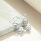 Indulge in sophistication with Sterling Silver 8mm Pearl Drop Earrings, a fine jewelry accent for women.